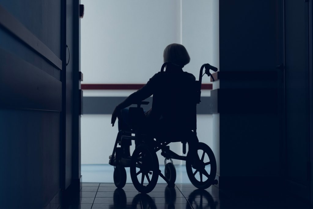 Woman sitting in wheelchair dark hallway