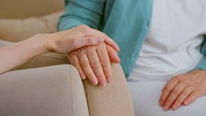 Caregiver cheers up senior lady patient